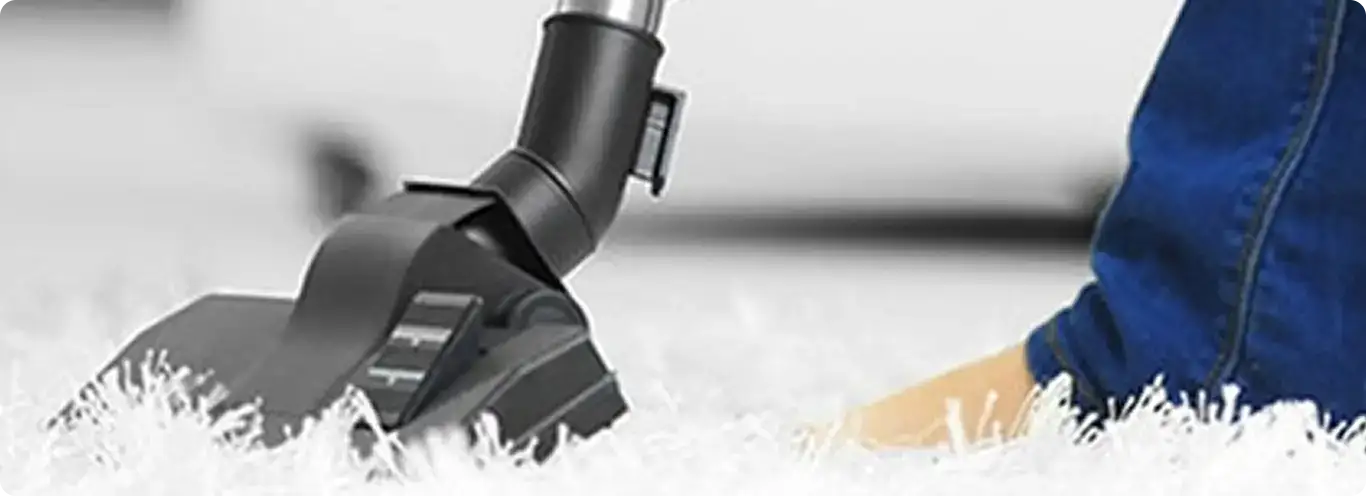 Close-up of a professional vacuuming a white carpet in North Providence.